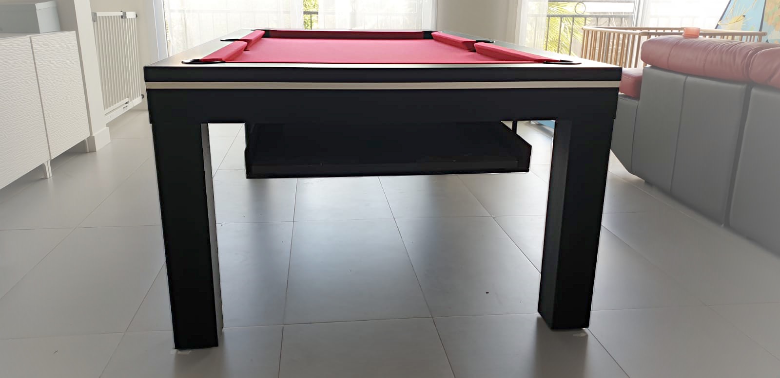 La nacelle retractable sous le cadre permet de ranger précieusement les éléments du plateau qui transforme le billard NOVEA en table design finition nano noir a liseré blanc. À l'achat d'un billard transformable en table il est judicieux de penser au rangement des plateaux de table.